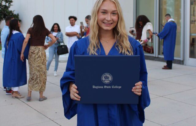 Taylor holds up her college degree