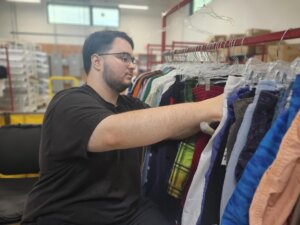 David hanging textiles in the processing area